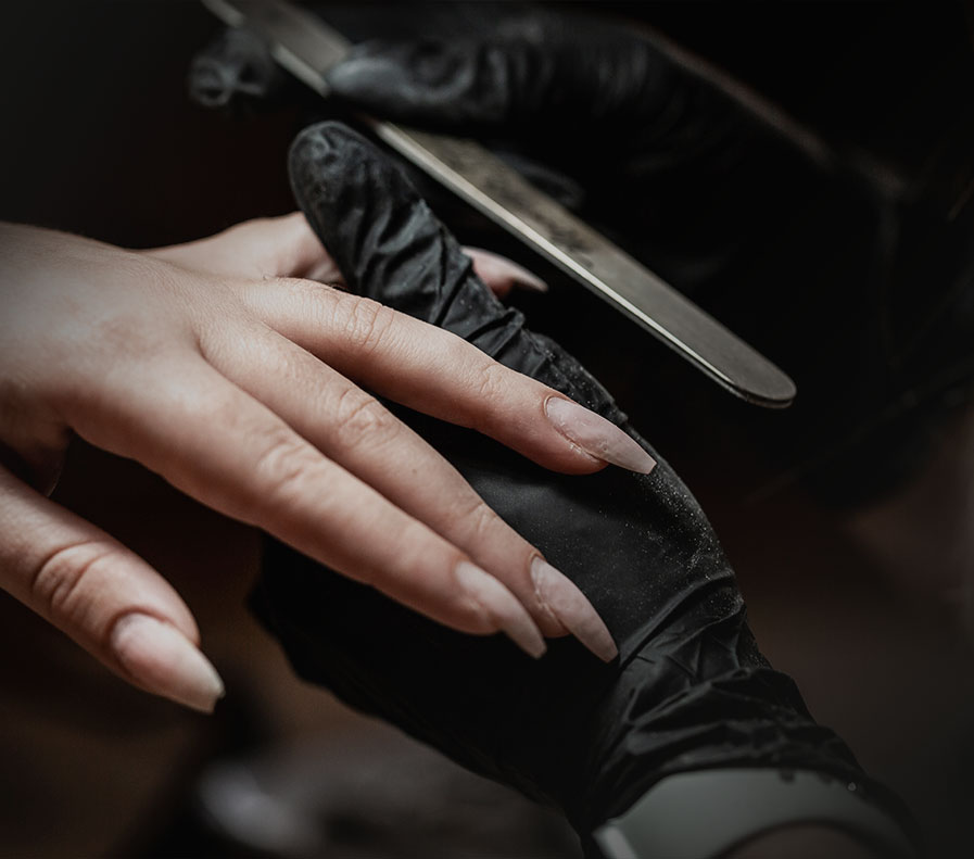 Eine Frau lässt sich in einem Nagelstudio die Nägel machen.